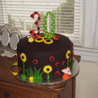Black Celebration Cake 3 layer 12" round with Bumble Bee, Lady Bug and Toadstools2 layers of vanilla cake, 1 layer of chocolate with vanilla buttercream...