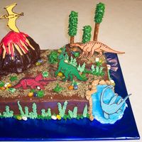 Dinosaur Cake Chocolate cake with buttercream icing. I used a design by DianeLM. Mine is a sad version of hers, but my son loved it! The dinosaurs are...