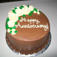 Chocolate Buttercream Cake 8" round cake iced smooth with Chocolate buttercream and decorated with ivory buttercream roses!