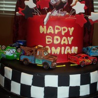 Cars Birthday Cake This cake is devil's food with cookies and cream. Very moist and yummy! The flag around the side and the letters were much harder to...