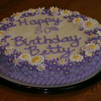Floral Birthday Cake a white confetti cake with buttercream frosting and royal icing flowers lining the edges. It was done in different shades of lavender.