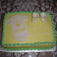 Baby Shower Cake Iced in buttercream. The onesie is MMF and the booties are MMF/gumpaste.