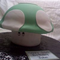 One Up Mushroom Super Mario Brothers Base is a round fondant covered craft box. Eyes done w/ edible markers. 3d soccer ball pan for top covered in fondant.