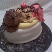 Banana Split Cake Oval cakes covered in Wilton fondant. Half egg pan to make ice cream balls covered in buttercream icing and melted chocolate with gumpaste...