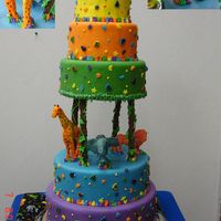 Jungle Birthday Cake Colorful tiered birthday cake with Mexican Paste lions, giraffe and elephant. Cake was created to compliment a fabric tablecloth matching...
