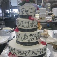 Pink/grey Wedding All buttercream with charcoal grey ribbon and scroll work. Fresh flowers/petals.