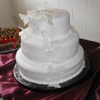 Butterfly Wedding Cake White fondant with a white pearl dust....butterfles are fondant....inside the cake is a french vanilla flavor with vanilla buttercream...