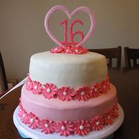 16Th Birthday Daisy Cake 2 tiers, 1 10" strawberry with strawberry buttercream and 1 8" vanilla cake with vanilla buttercream icing. The topper is a royal...