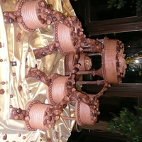 Chocolate Explosion With Chocolate Bridges White, yellow and chocolate cakes iced in chocolate buttercream. Fondant/gumpaste bridges. Plates and pillars covered in chocolate fondant...