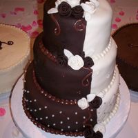 1/2 And 1/2 Cake Dark Chocolate fondant (mixed with some white to lighten it up); ivory fondant; fondant roses; buttercream and ganace decorations