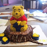 Pooh Bear On A Stump stand up winnie the pooh cake on top of a 12 in. round spring formcake decorated to look like a tree stump