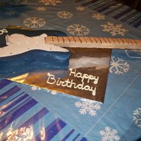 Guitar Cake Yellow cake with buttercream frosting coved in fondant. The neck is rice crispy