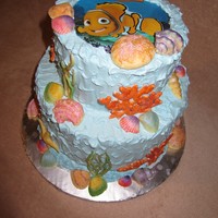 Nemo Finding Nemo theme. Buttercream icing, edible image on top, hand painted white chocolate shells and royal icing corals.