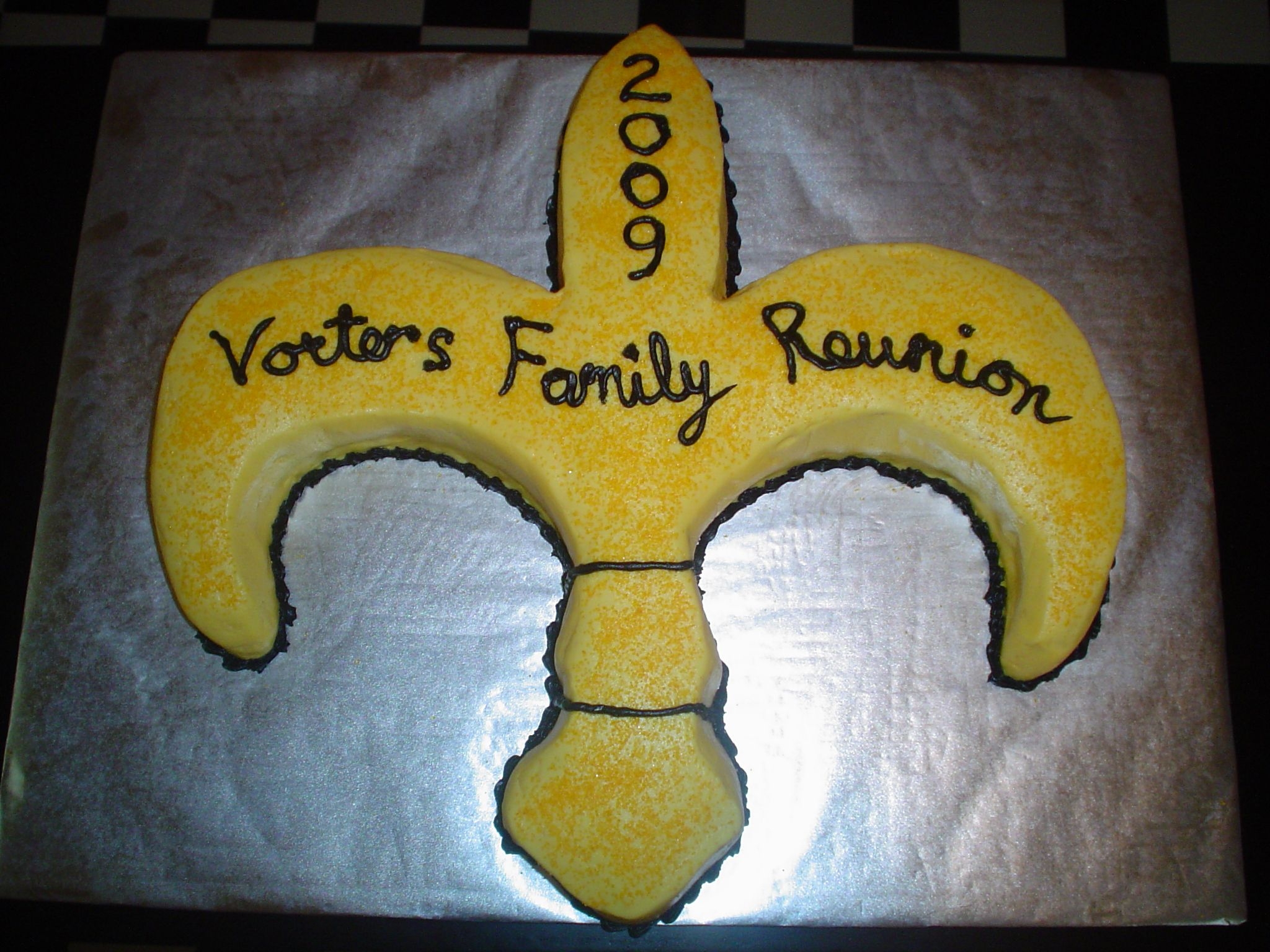 Fleur De Lis Cake two 12 inch rounds, carved to shape fleur de lis. White cake with lemon buttercream icing.