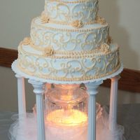 My First Wedding Cake This was the first wedding cake I ever did. It's a 3 tier w/white buttercream and ivory 1/2 circle designs on the side. The fountain...