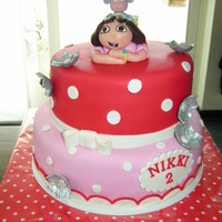 Dora The Explorer Dora and boots on top of a red and pink polkadot cake!