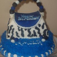 Blue/black Purse bottom (blue) cake is chocolate cake with buttercream icing, the purse is white cake with buttercream incing covered with fondant!