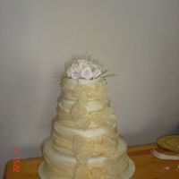 Elegance A four tier vanilla sponge (English) filled with a vanilla buttercream (English) and an apricot preserve,dressed in an ivory fondant and...