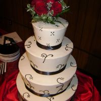 Rose All buttercream iced with buttercream designs. Beautiful fresh red roses top the tapered tiers with black ribbon on the bottoms of each...