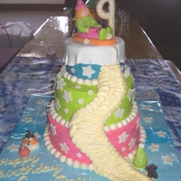 Winter Sledding 3 tiered, covered with icing, neon colors; Fondant girl sledding, snow top and snowballs around boarder; Gumpaste stars (supposed to be...