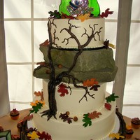 Autumn Tree Wedding Cake Ivory buttercream iced round tiers sitting on a log cake stand features a piped buttercream tree climbing up the tiers and rocks (Yes, they...