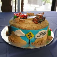 Cars Cake The rocks, clouds, hills, cactus, etc. were all made of rolled buttercream. The inside was black and white checker to represent the...