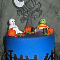 Halloween Fondant covered and airbrushed with gumpaste accents. Tree, moon and fence are cut with the Cricut, all other things are hand done.