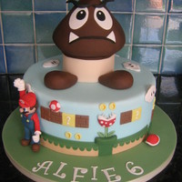 Super Mario Cake 11" chocolate sponge cake with vanilla b/c and caramel filling, covered in fondant with gumpaste figure.Thanks for looking.