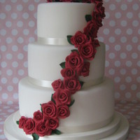 Red Rose Wedding Cake 10",8" and 6" vanilla sponge cake with vanilla b/c and raspberry jam filling, all covered in fondant with gumpaste roses....