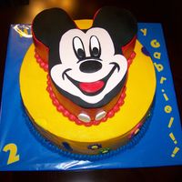 Mickey Mouse Mickey Mouse carved from a 10" square stacked on a 14" round. Bottom tier is WASC with strawberry cream and fresh strawberries...