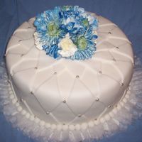 Blue Diamond made with fondant and accented with silver pearls and a bouquet of blue dyed flowers