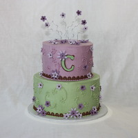 Purple Green & Brown W/ Flowers 6" 8" Rounds iced in buttercream with fondant flowers and wire curly-q's on top.