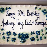 A Grandpa's Birthday Cake Gold cake, buttercream frosting with yellow tipped blue roses and buds.