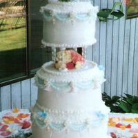 Doves And Flowers This cake is made with the beveled cake pan set. It has bells, doves and flowers on it. The flowers in between the tiers are fresh.