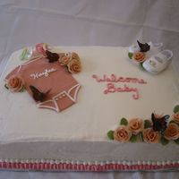 Haylee Half white, half chocolate cake... All buttercream with fondant accents and rice paper butterflies. Purchases baby shoes and pacifiers.