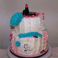 Ruffle Birthday Cake Cake iced in buttercream and then each "lasagne" ruffle placed on. All other decor is fondant and a few edible gems.