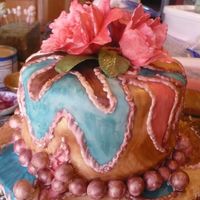 Happy Birthday Andrea! This is a carrot cake with a white chocoate buttercream fillingand is covered with a white fondant. Colors were custom mixed for this cake...
