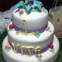 Fairy Tale 1St Birthday 3 layer (10/8/6) cake covered in fondant with fondant and gumpaste figures. The cake was then sprayed with PME shimmer spray.