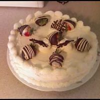 Cheesecake Cheesecake frosted in real whipped cream topped with chocolate covered strawberries.