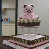 Pink And Brown Stand Up Bear Pink stand-up bear sits on 10" round cake. Columns hold bear and round on 14" square cake. Decorated with chocolate buttercream...