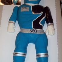 Blue Power Ranger Mde From a 1/2 Sheet cake, 2 layer 6" for helmet and 2 cupcakes for each foot. Placed on a Full size sheet cake board- He barely fit...