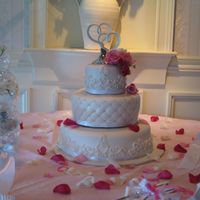 White Scroll Wedding Cake 14", 10", 6" covered in fondant. Fondant scrolls, silver dragess in quilt crosspoints, fresh flowers. Scrollwork is design...