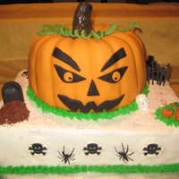 Haloween/pumpkin Cake Pumpkin Spice Jack-O-Lantern covered in Fondant with gumpaste leaves and fondant eyes, nose, mouth. Vanilla two layer cake under it frosted...