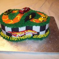 Hot Wheels Cake CSM: 2 eight in rounds stuck together with a cake bridge. Covered in buttercream then fondant accents. The cars were bought, and the track...