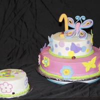 First Birthday Cake 12" bottom is chocolate cake with fresh strawberry filling. 8" is yellow with buttercream filling. Iced in buttercream, fondant...