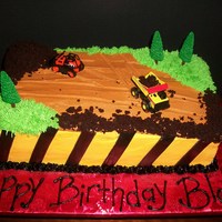 Construction Truck Cake Double layer 1/2 chocolate with fudge filling and 1/2 french vanilla with vanilla cream filling. Iced in yellow BC with black fondant...