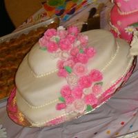 Rose Heart Cake It is a 3 tiered cake covered in vannila icing and fondant. Covered in pink fondant roses with pink and white luster dust painted on it. My...
