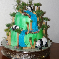 Panda Bear Cake this was for a Panda Bear themed baby shower! Two tiers, fondant, chocolate rocks, buttercream icing, and pirouette cookies for the tree...