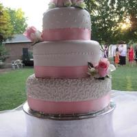 Pretty In Pink White fondant with buttercream details. Fresh roses and orchids decorate the cake.