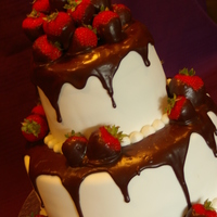 Fresh Strawberries And Chocolate Ganache! White fondant over red velvet cake, layered with chocolate ganache. Chocolate ganache drizzled over cake with fresh dipped strawberries!